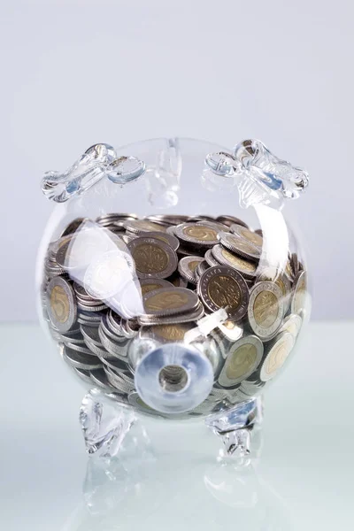 Glass piggy bank with coins inside — Stock Photo, Image