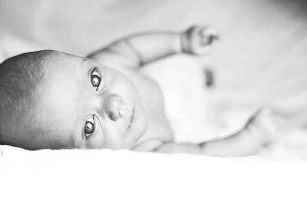 Schönes kleines Mädchen auf weißer Decke — Stockfoto