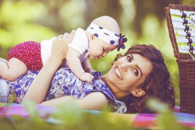 Genç anne ile bebek battaniye parkta oynarken