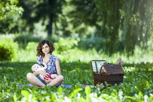 Giovane madre che allatta un bambino nel parco — Foto Stock