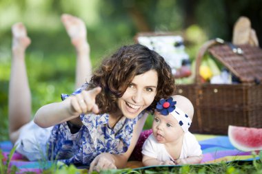 Genç güzel anne kızıyla birlikte park battaniyeye oturur