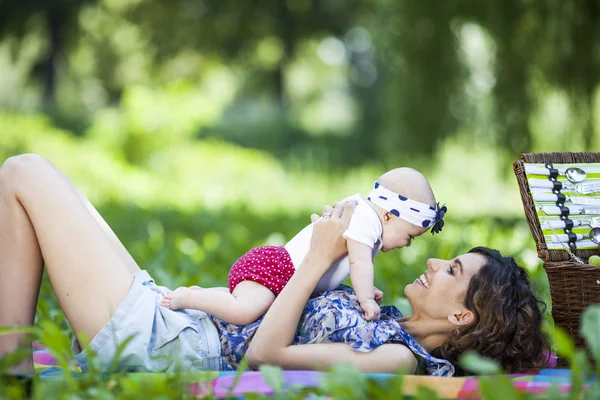 Genç anne ile bebek battaniye parkta oynarken