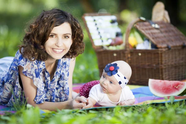 Genç güzel anne kızıyla birlikte park battaniyeye oturur