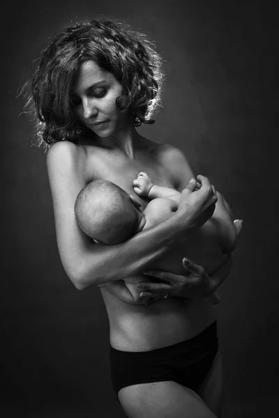 Young mother holding a baby in her arms — Stock Photo, Image