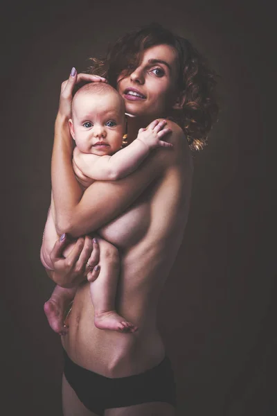 Young mother holding a baby in her arms — Stock Photo, Image