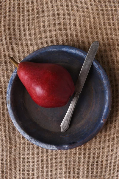 Coltello per pere rosso e piatto blu — Foto Stock
