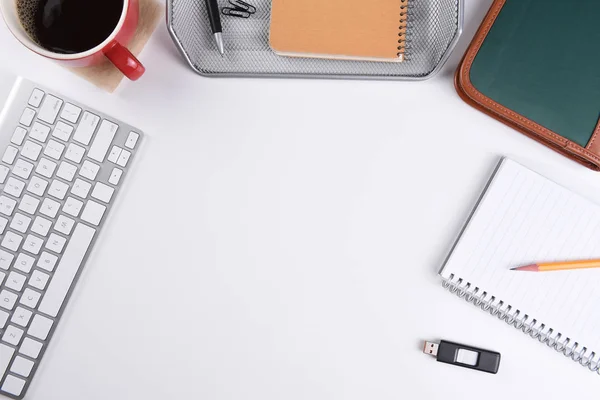 High angle shot of a white business desk, with coffee, note pad and other office equipment. — Stock Photo, Image