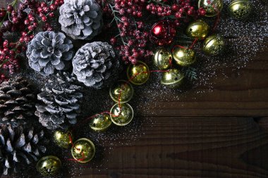 Jingle bells, pine cones and red berries on a rustic wood table clipart