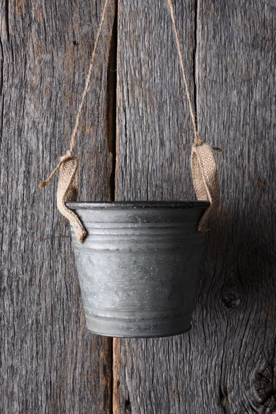 Cubo vacío colgando de una pared de madera — Foto de Stock