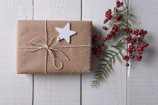 Einfach verpacktes Weihnachtsgeschenk mit einem Stern-Geschenk-Anhänger — Stockfoto
