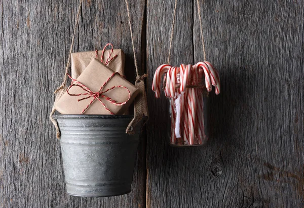 礼物和糖果手杖挂在一个质朴的木墙 — 图库照片