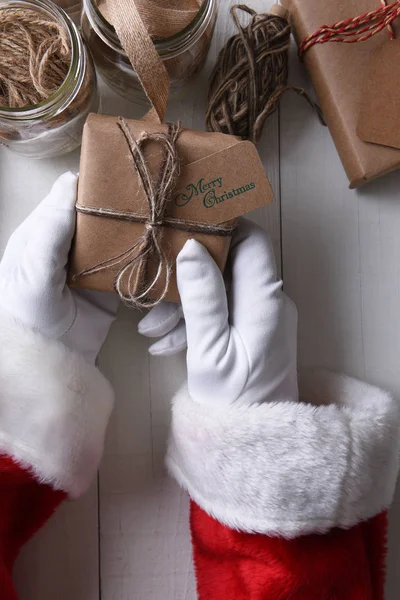 Santa bedrijf een vlakte verpakt kerstcadeau — Stockfoto