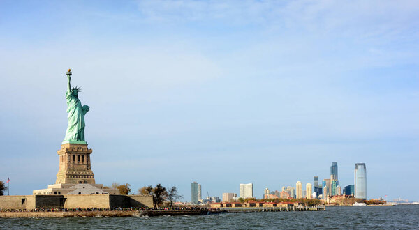 The Statue of Liberty and Ellis Island with the Jersey City skyline in the background.