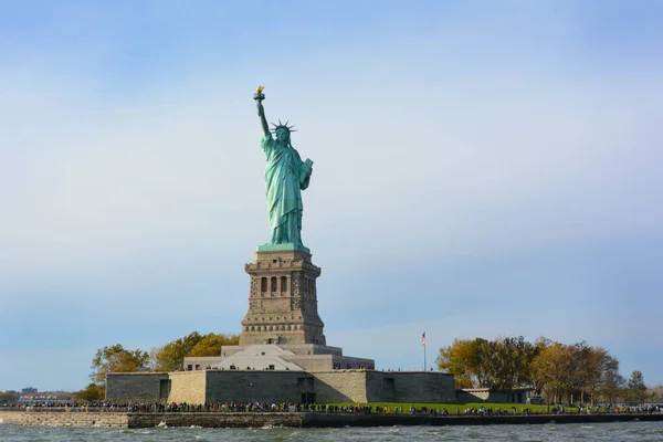 A Estátua da Liberdade em New York Harbor com visitantes em torno de um — Fotografia de Stock
