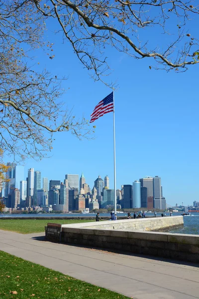 NUEVA YORK, NY - 04 NOV 2019: Bandera en Ellis Island con Manhattan — Foto de Stock