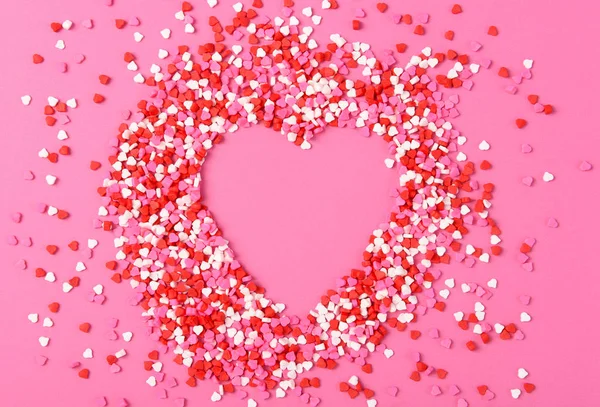 Valentined Day Concept: Heart Shaped candy sprinkles on a pink s — Stock Photo, Image