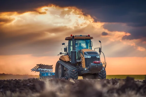 Agricultor en tractor preparando tierra con cultivador —  Fotos de Stock