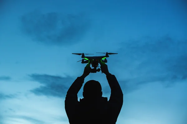 Az ember, aki a drone, a légi felvételek. Sziluettjét ellen — Stock Fotó