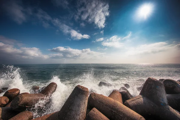 Морские волны, разбивающиеся о скалы с брызгами — стоковое фото
