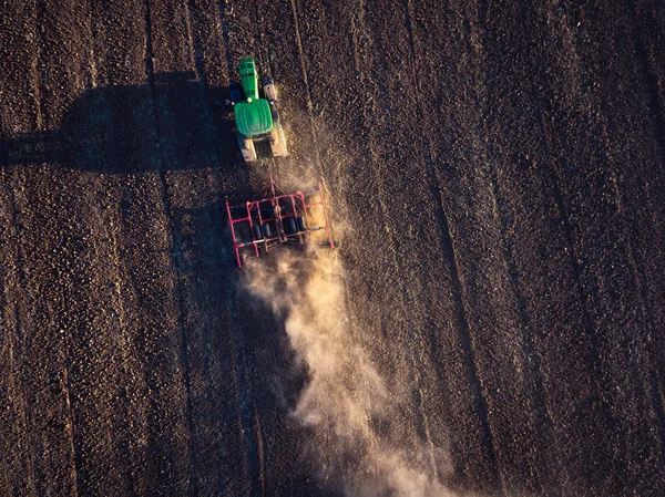 Agricultor em trator preparando terra com cultivador — Fotografia de Stock