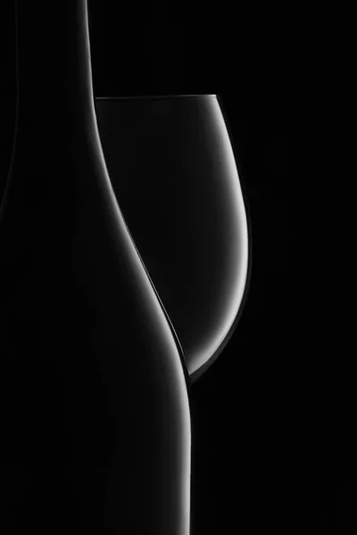 Пляшка і келих білого вина на чорному — стокове фото