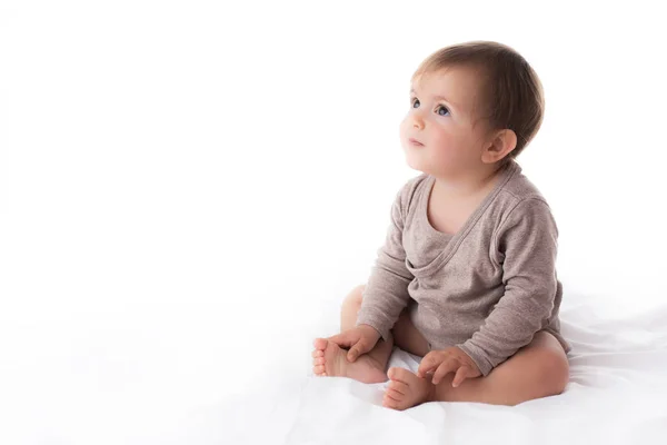 Förtjusande baby flicka stående på vit bakgrund — Stockfoto