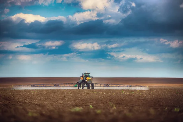 Mezőgazdasági traktor szántása és permetezése mezőn — Stock Fotó