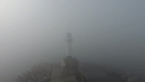 Salida del sol sobre el faro en niebla densa y niebla, vista aérea — Vídeos de Stock