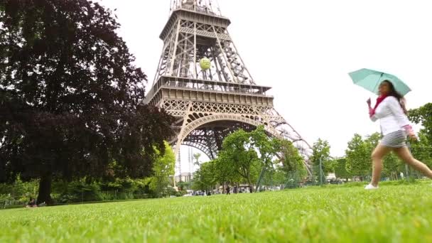 Leuke mooie jonge vrouw in jurk dansen met paraplu voor de toren van Eiffel, Paris, Frankrijk. — Stockvideo