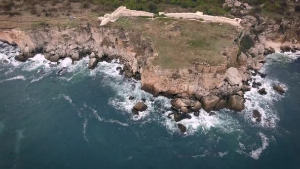 Вид с воздуха на скалистое побережье с кустарником и древнюю крепость — стоковое видео