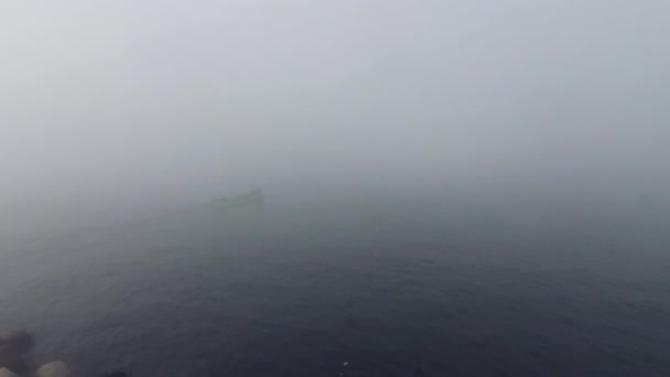 Barco en el agua de mar brumosa cerca de la costa, vídeo aéreo — Vídeo de stock