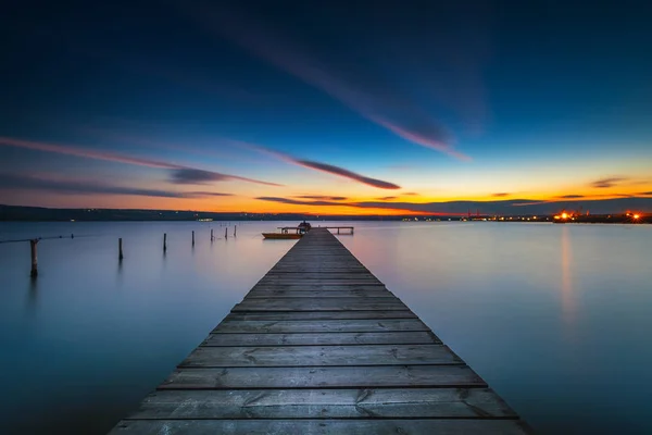 Fából készült dokk és csónak a tó, naplemente szemcsésedik — Stock Fotó