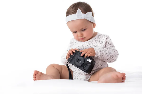 Beyaz arka plan üzerinde kamera ile oynarken güzel kız bebek — Stok fotoğraf