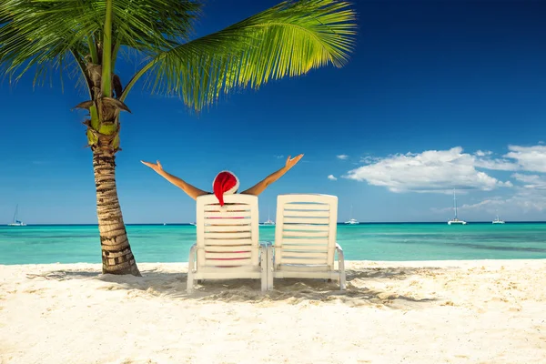 Şapka Noel Baba'nın tropikal plaj rahatlatıcı kadında — Stok fotoğraf
