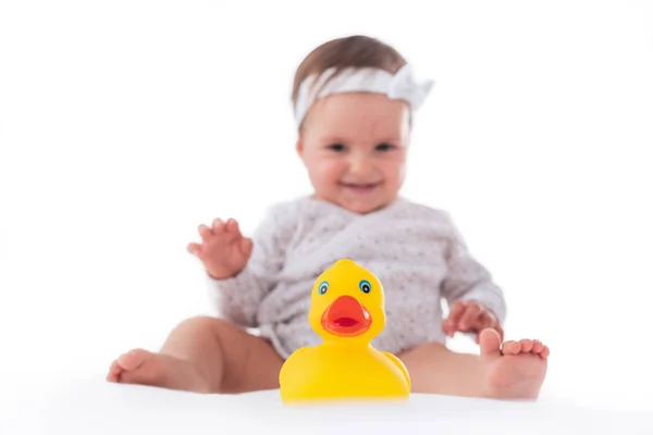 Cute baby girl playing with yellow rubber duck isolated — Stock Photo, Image