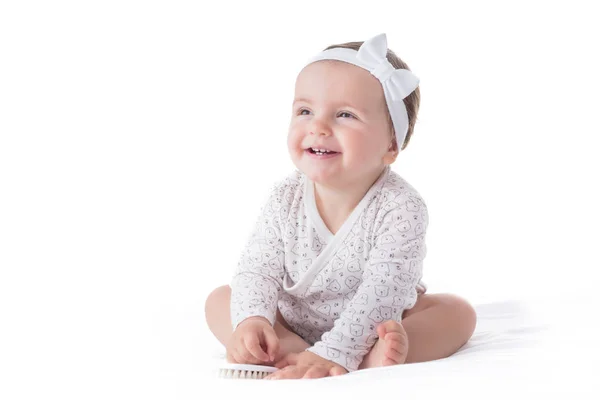 Bir güleryüzlü bir beyaz bac üzerinde saç fırçası ile kız bebek portresi — Stok fotoğraf