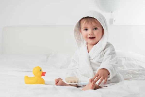Küçük bebek beyaz havlunun altında gülümsüyor — Stok fotoğraf