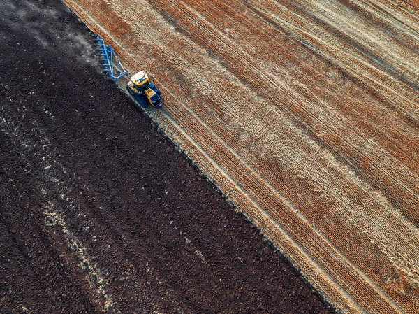 Tractor cultivating field at autumn — Stock Photo, Image