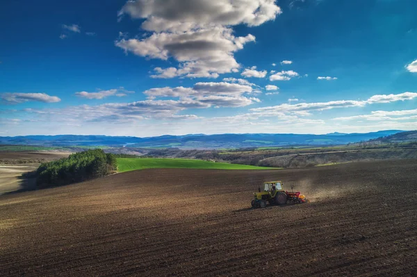 Hasat tarlasında çalışan traktörün hava görüntüsü.