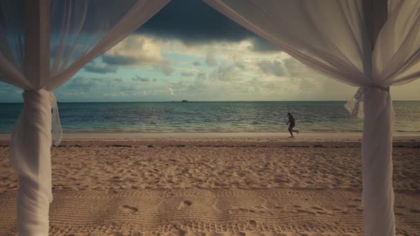 Île tropicale plage lever du soleil et courir homme sur le sable — Video