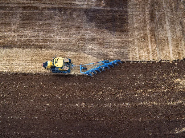 Tractor cultivating field at autumn — Stock Photo, Image