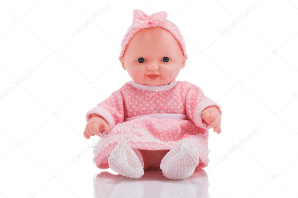 Cute little plastic baby doll with blue eyes sitting  isolated o