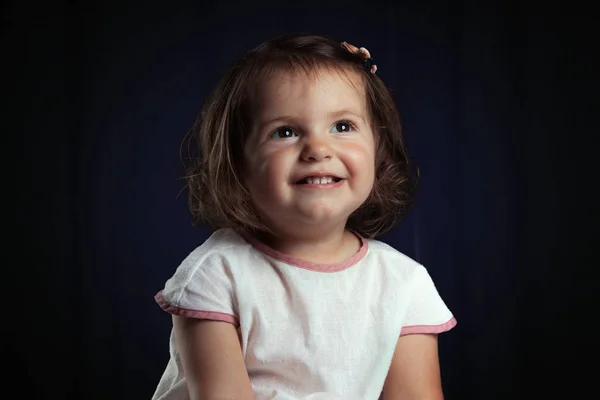 Schattige kleine lachende baby meisje portret op zwarte achtergrond — Stockfoto