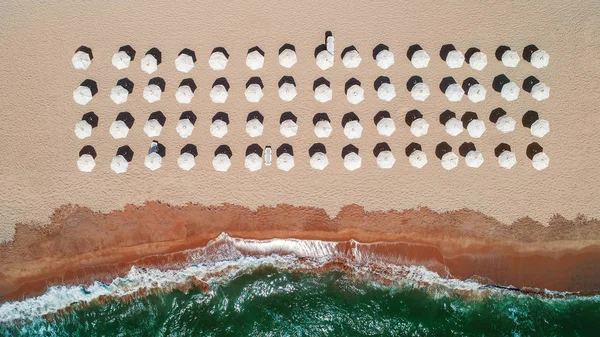 Vista aerea dall'alto sulla spiaggia. Ombrelli, sabbia e onde marine — Foto Stock