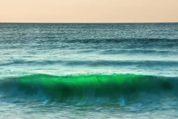 Büyük dalgalar denizde sıçramasına gündoğumu — Stok fotoğraf