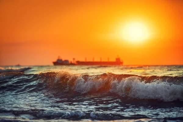 Sonnenuntergang am Meer mit segelndem Frachtschiff, malerische Aussicht — Stockfoto