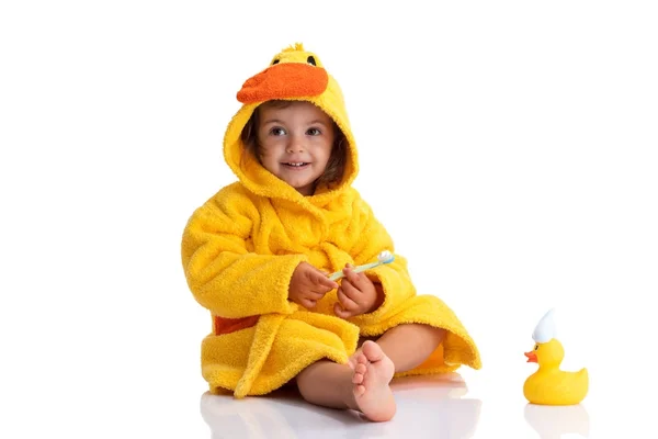Kleine baby glimlachend onder een gele handdoek en zijn tanden poetsen — Stockfoto