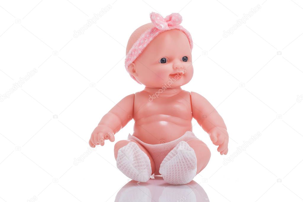 Cute little plastic baby doll with blue eyes sitting  isolated o