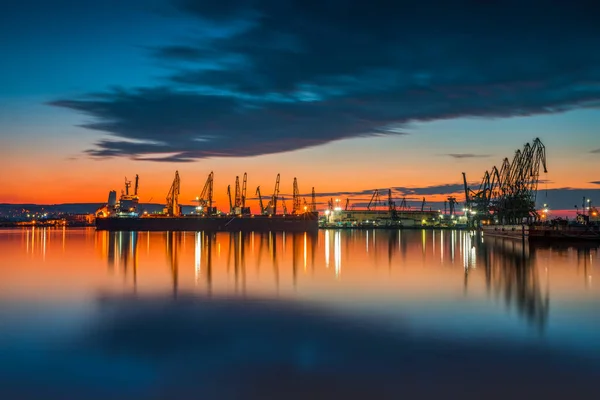 Ηλιοβασίλεμα πάνω από το λιμάνι και βιομηχανικοί γερανοί, Βάρνα. Βουλγαρία. — Φωτογραφία Αρχείου