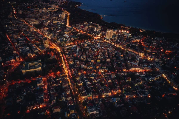 Letecké noční pohled přes město Varna, Bulharsko. Moře, světla a budovy — Stock fotografie